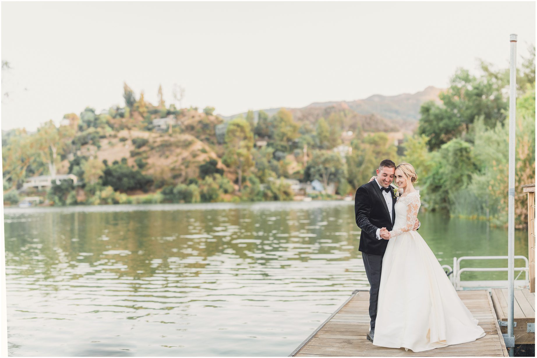 A bride and groom pose near Malibou lake at their wedding, hosted at the Malibou Lake Lodge