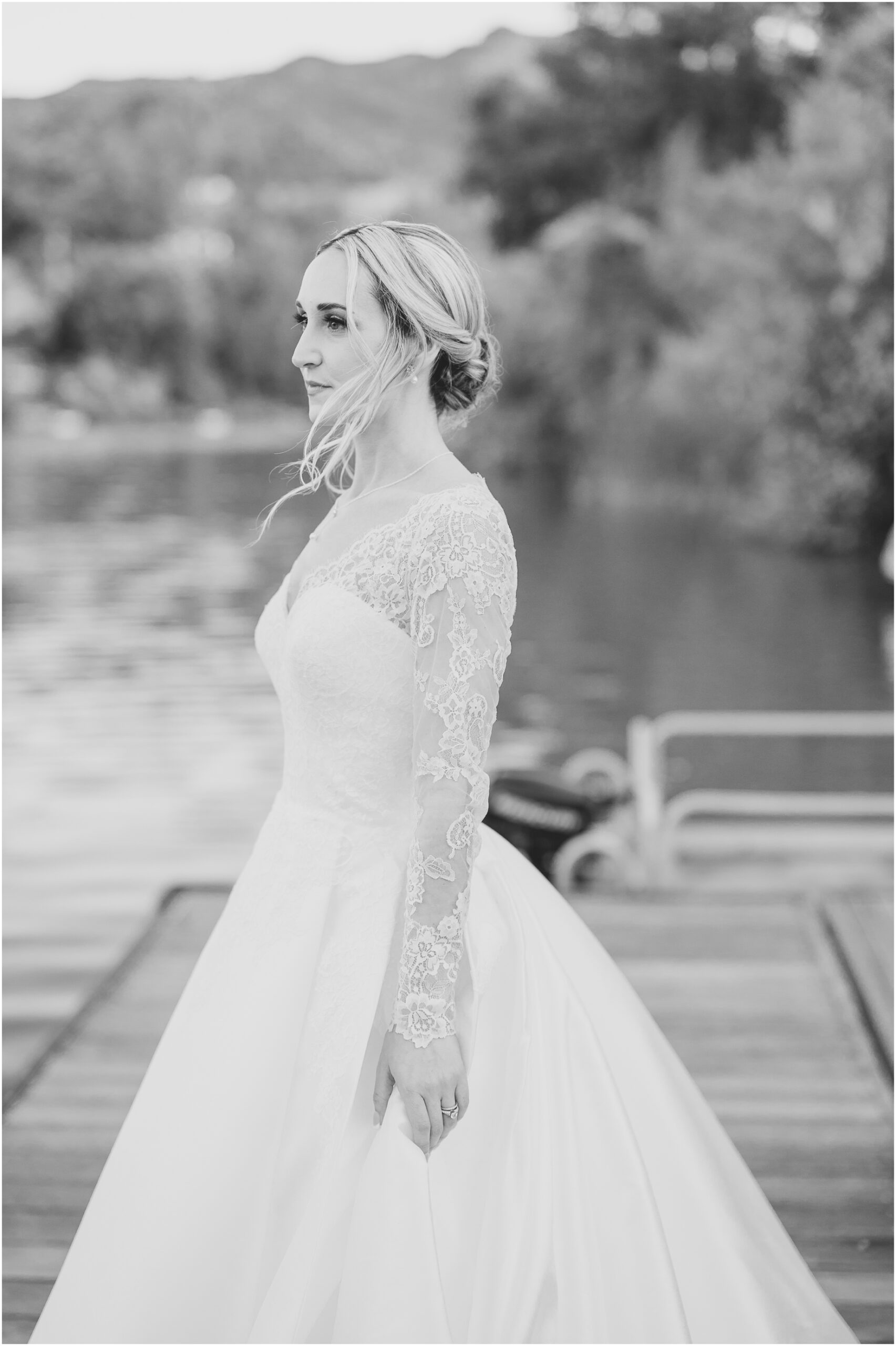 A bride takes a moment of introspection in the middle of her wedding day as she stands on a dock at Malibou Lake
